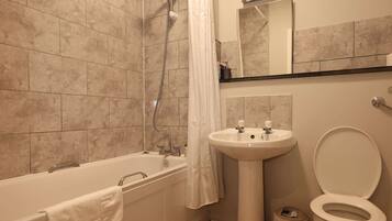 A bathroom with a bathtub, sink, and toilet.