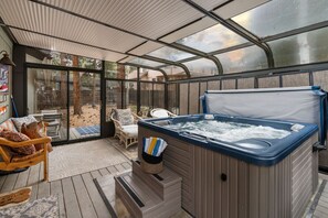 A hot tub in a covered outdoor area with chairs and a table. - Skyline Stargazing Cabin with hot tub (Flagstaff)