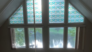 A high-ceilinged room with large windows and a view of the outdoors.