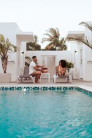 Una piscina al aire libre, sillones reclinables de piscina