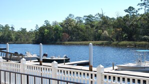 A dock with boats, a white fence, and a forested shoreline. - Steinhatchee Landing Resort-# 5 Nautical Cottage-Boat slip-Newly remodeled (Steinhatchee)