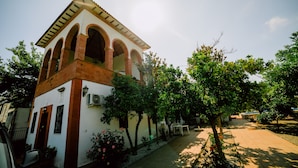 A building with a white facade and red brick accents, featuring a tower with arches and a tiled roof. - San Antonio Rural House. Villa 3 (3 bedrooms) (Cabra (Córdoba))