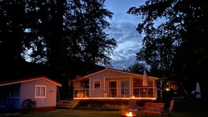 Ein Haus mit Terrasse, Feuerstelle und einem Stuhl.