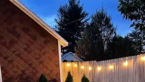 A well-maintained garden with a wooden fence, neatly trimmed grass, and decorative lighting. - Hersheypark 3.4 miles-Open floor plan (Hummelstown)