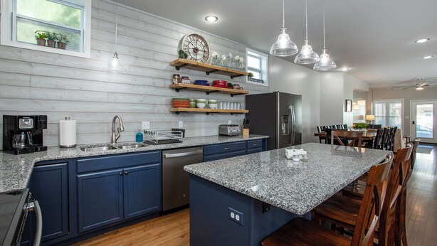 A modern kitchen with granite countertops, blue cabinets, a built-in island, stainless steel appliances, and pendant lighting. - Hersheypark 3.4 miles-Open floor plan (Hummelstown)