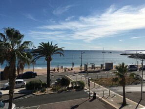 A coastal road with palm trees, a beach, and a clear sky. - Beautiful 2 bedroom apartment by the sea (4 pers) (Fréjus)