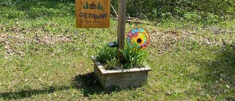A wooden sign with the text "Sugar Bush Getaway" and a colorful windmill.