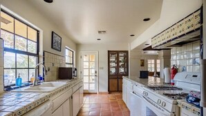 Una cocina con una isla grande, estufa y lavamanos.