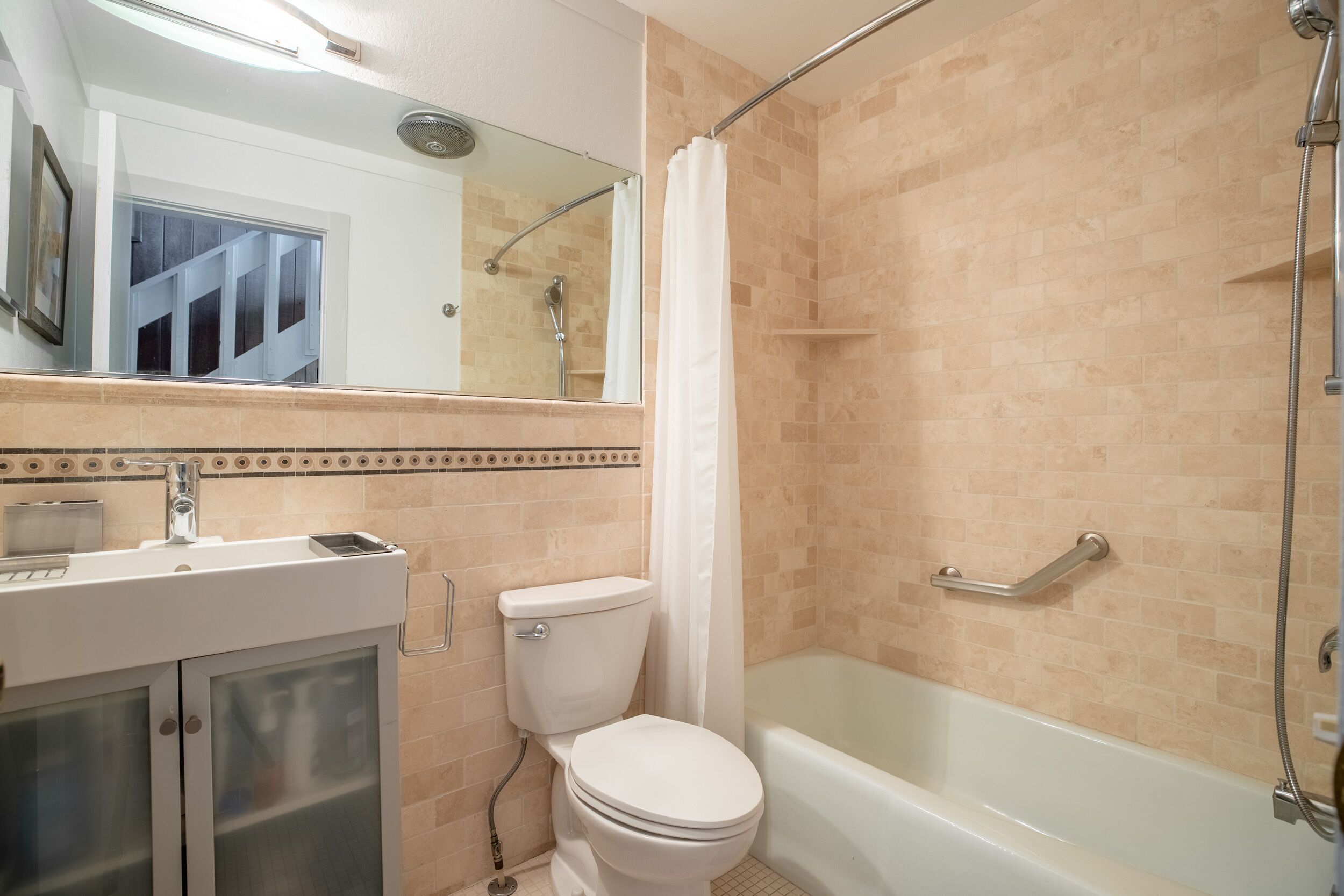 Une salle de bain avec des toilettes, un lavabo et une baignoire.