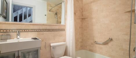 A bathroom with a toilet, sink, and bathtub.