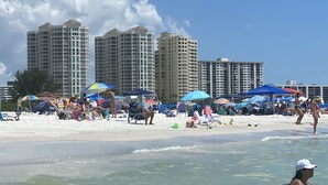 Une plage avec des parasols et des gens.