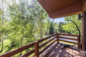 A wooden deck with a view of a forest.