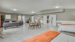 A spacious room with a bed, a sofa, a dining table with chairs, and a kitchen area. - 🌞6 KING beds, 14 GUESTS, 5 BEDROOMS, 2 BATHROOMS, REFRIGERATION, NEAR AIRPORT (El Paso)