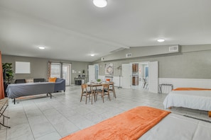 A spacious room with a bed, a sofa, a dining table with chairs, and a kitchen area. - 🌞6 KING beds, 14 GUESTS, 5 BEDROOMS, 2 BATHROOMS, REFRIGERATION, NEAR AIRPORT (El Paso)