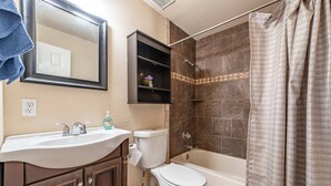 Ein Badezimmer mit Waschbecken, Toilette, Badewanne und Duschvorhang.