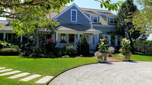A two-story house with a covered porch and a well-maintained lawn.