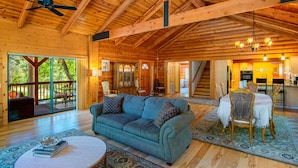A spacious wooden interior with a sofa, dining table, and chairs.