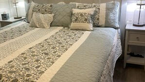 A neatly made bed with patterned bedding and a decorative headboard. - Maes Cottage In The Clouds (Blue Ridge)