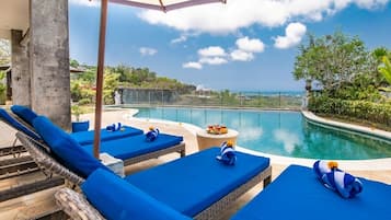 Una piscina al aire libre, sombrillas, tumbonas