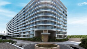 A modern hotel with a curved facade, multiple balconies, and a central courtyard with a fountain. - Nima Bay Lifestyles Experience (Puerto Vallarta)