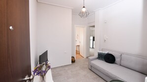 A modern living room with a grey sofa, a small table, and a decorative vase with flowers.