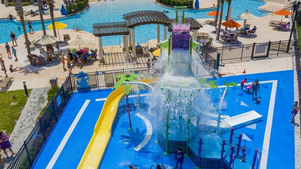 A water park with multiple slides and a central water feature. - Charming 3BR Townhome - Private Pool - Walk to Clubhouse - 9 Min Disney! (Kissimmee)