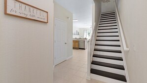 A staircase leading to a kitchen area with a sign on the wall that reads "THANKFUL for every little moment." - Charming 3BR Townhome - Private Pool - Walk to Clubhouse - 9 Min Disney! (Kissimmee)
