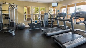 A gym with treadmills, elliptical machines, and weight equipment. - Charming 3BR Townhome - Private Pool - Walk to Clubhouse - 9 Min Disney! (Kissimmee)