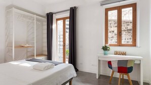 Une chambre à coucher comprenant un lit, un bureau, une chaise et une armoire.