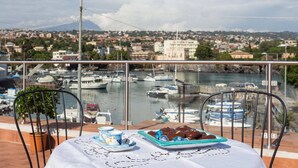Une table donnant sur un port, une chaise et une plante en pot.