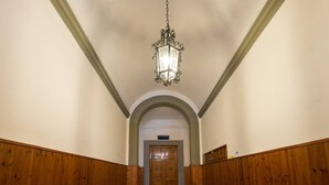 A hallway with wooden paneling, a hanging lantern, and a door at the end. - Duomo View Rooftop Terrace - Bright & Quiet 3 Bedroom 2 Bath (Firenze)