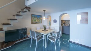 A modern interior with a dining area, kitchen, and staircase. - Casa Stella Marisa Positano - Unique Sea View Terrace near Beach & Center (Positano)