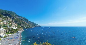 A coastal view with a marina, beach, and hillside buildings.