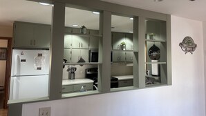 A kitchen with white cabinets, a refrigerator, and a coffee sign on the wall. - Hideout On Lake Delton ( Known as the Getaway ) (Lake Delton)