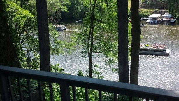 A river with boats, surrounded by trees. - Hideout On Lake Delton ( Known as the Getaway ) (Lake Delton)