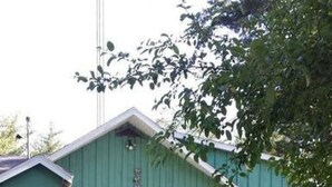 A green building with a deck and a fenced area. - Hideout On Lake Delton ( Known as the Getaway ) (Lake Delton)