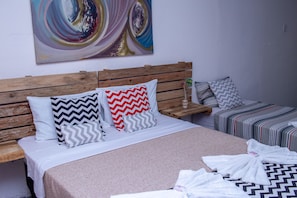 A hotel room with a wooden headboard, a bed with striped bedding, and a colorful abstract painting on the wall. - Pousada Pêlo De Imbassai (Mata de São João)
