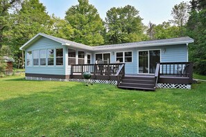 A light blue cabin with a porch, a deck, and a lawn. - Ebert's Hideaway with Great Access to Dock and Stunning Views of Lake Namakagon (Cable)