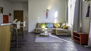 Ein modernes Wohnzimmer mit einer Couch, einem Couchtisch und einer Bar mit Hockern.