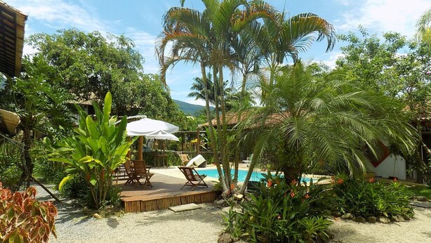 A pool area with lounge chairs and a wooden deck. - Pouso Atobá (Paraty)