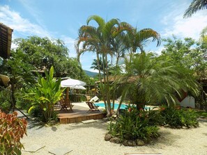 A pool area with lounge chairs and a wooden deck. - Pouso Atobá (Paraty)