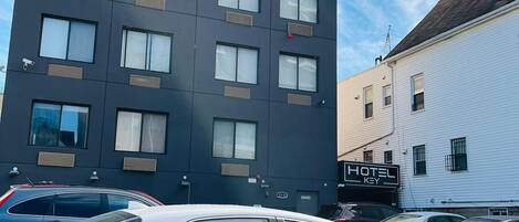 A modern building with multiple windows and a sign that reads "HOTEL KEY".