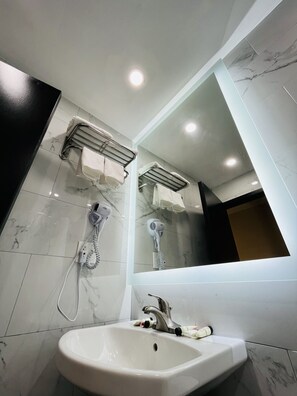 A modern bathroom with a white sink, a mirror, and two towel racks. - Hotel Key LaGuardia Airport (Flushing)