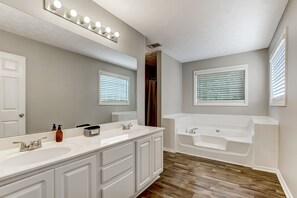 Een bad/douchecombinatie, een haardroger, handdoeken, zeep