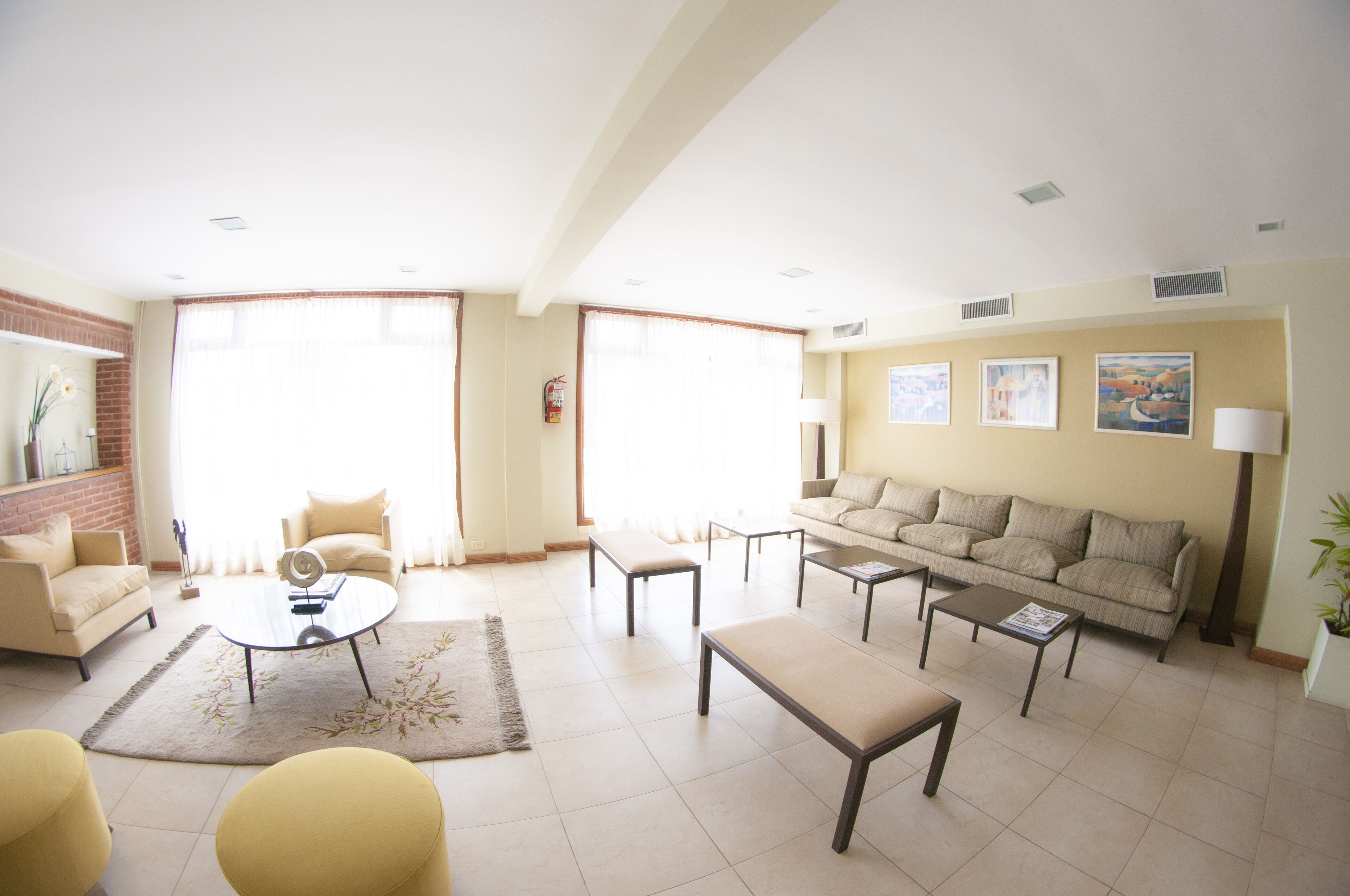 A spacious living room with a sofa, armchairs, a coffee table, and a fireplace.