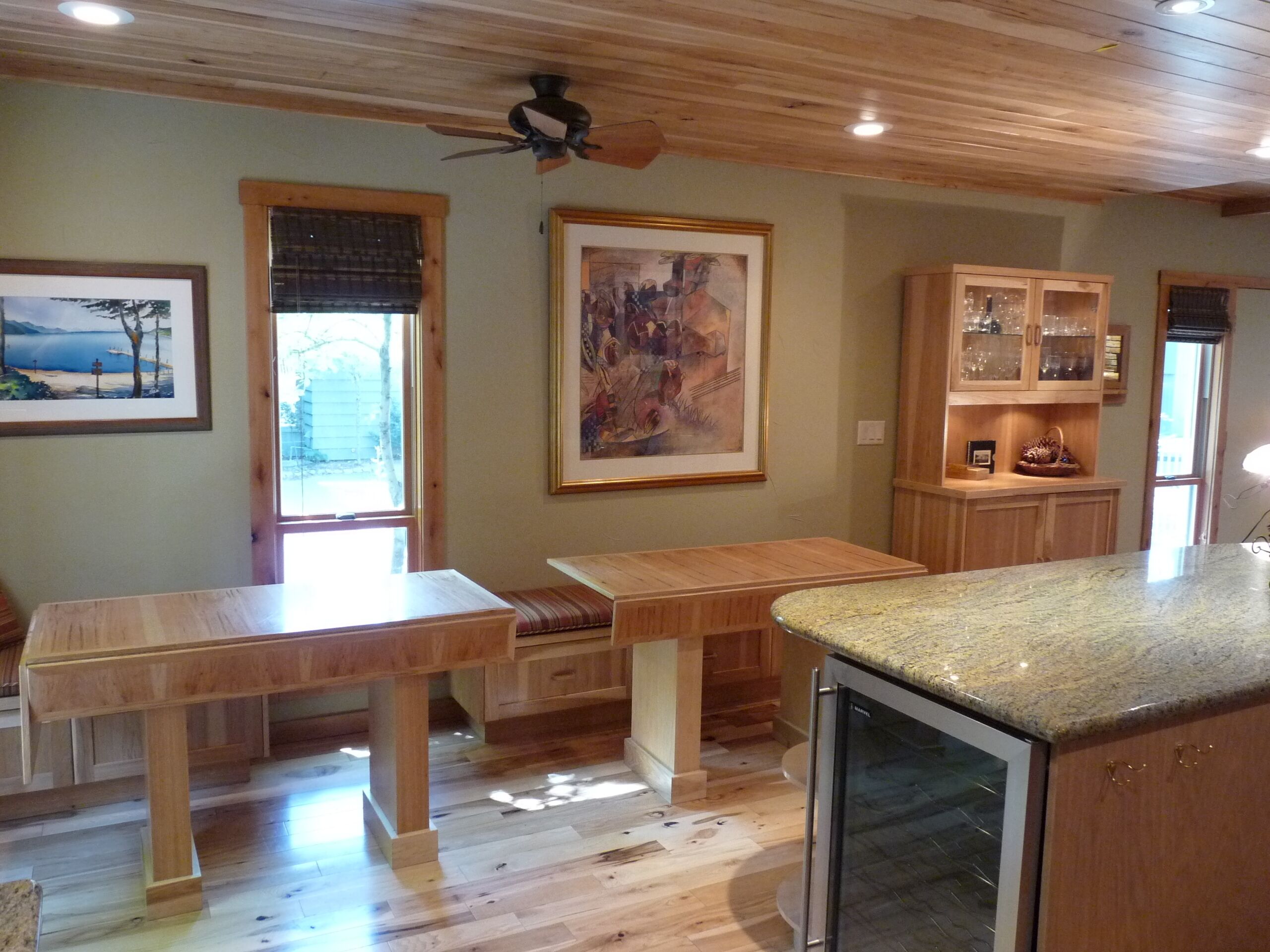 A kitchen with wooden cabinets, a granite countertop, and a ceiling fan.