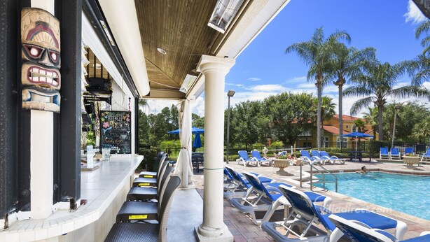 A poolside area with lounge chairs, a bar, and a sign for 'Biker Bar'. - Palm Key Villa by VillaDirect (Kissimmee)