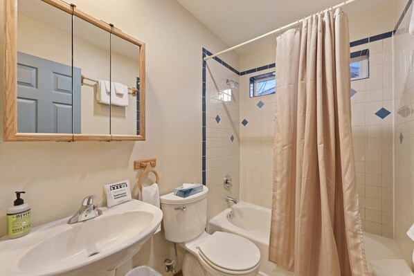 A bathroom with a sink, toilet, and bathtub. - Huckleberry Cottage - A/C, Hot Tub, Ping Pong, Walk to Everything, Perfect Bend Westside Cottage (Bend)