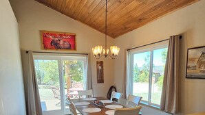 A spacious kitchen with wooden flooring, a central island, and a dining area with chairs and a table. - Mountain Meadow, 3-bedroom vacation home, close to RMNP & lakes, Hot tub, W/D (Grand Lake)