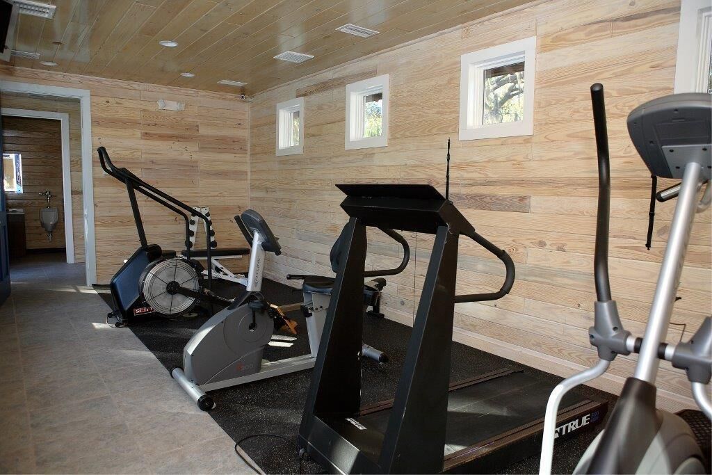 A gym with stationary bikes, a treadmill, and a rowing machine.